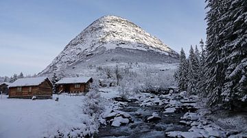 Besneeuwde bergtop en Noorse hytter bij  Øvstestølbrua op de Trollstigen route van Aagje de Jong
