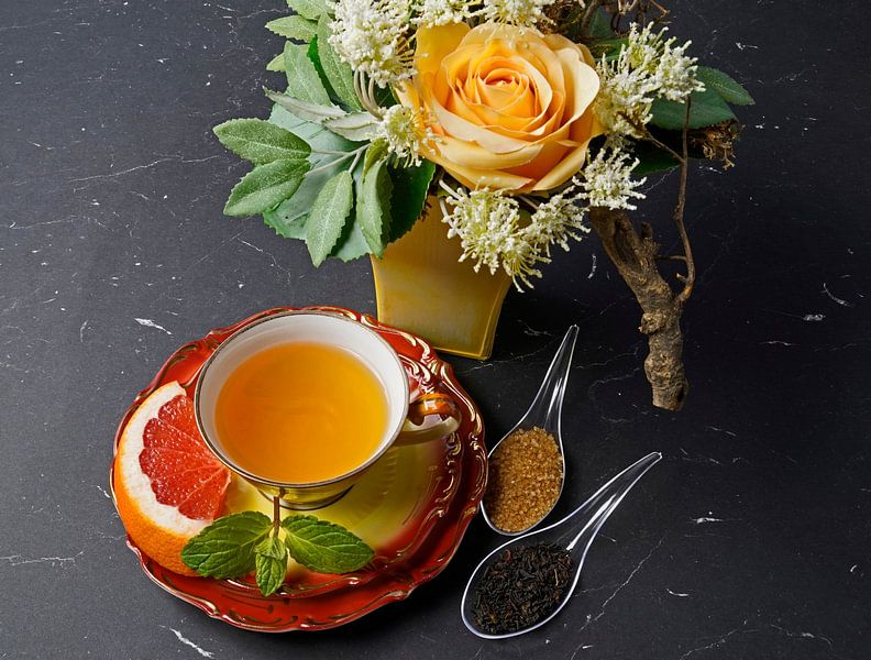 Schwarzer Tee mit Grapefruit in einer Tasse und Löffel mit Rohrzucker von Babetts Bildergalerie
