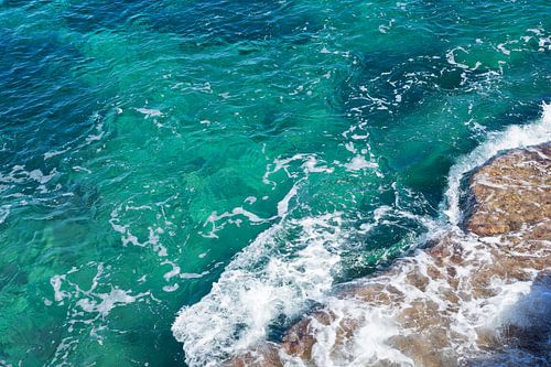 Helder zeewater stroomt over de rotsen 3