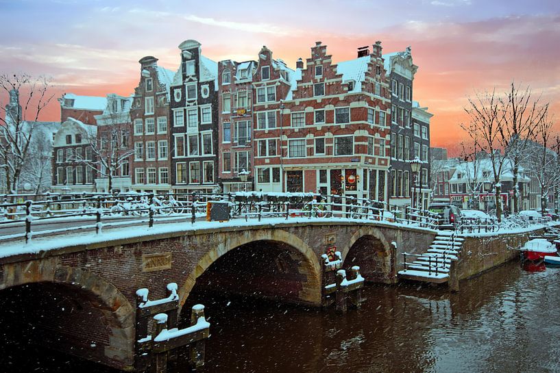 Besneeuwd Amsterdam in Nederland bij zonsondergang von Eye on You
