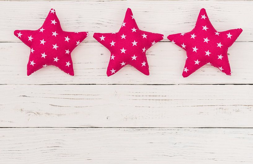 Pink stars decoration on white wooden background with copy space by Alex Winter