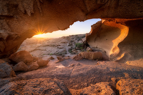 Zonsopkomst onder een stenen boog