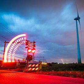 Een onweersbui nadert bij een windmolen en spoorwegovergang van Stefan Verkerk