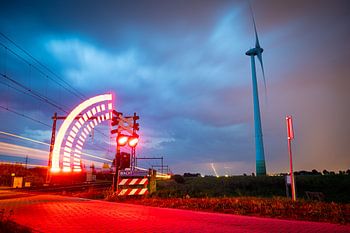 Ein Gewitter, das sich an einem Windmühlen- und Bahnübergang nähert.