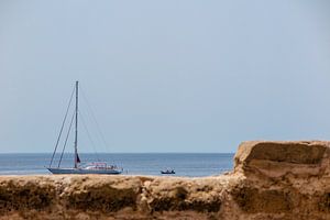lustiger Blick auf ein Segelboot mit einem Ruderboot an einer Wand