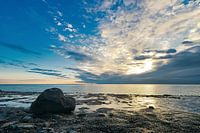 Large stone on the Zeeland coast at sunset