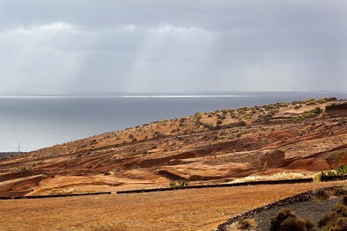 Zonnestralen op het water en landschap bij Arrieta op Lanzarote