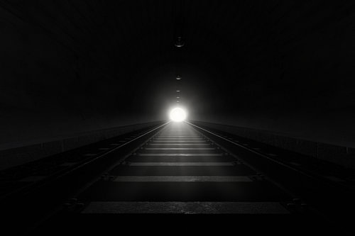 Donkere spoorwegtunnel met sporen en licht aan het einde van de tunnel van Besa Art