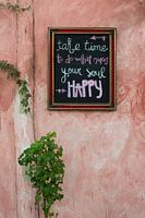 Cheerful text on chalkboard on old pink wall in Mexico