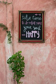 Texte joyeux sur un tableau noir sur un vieux mur rose au Mexique