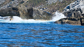 Norway by the fjord, spray on the rocks. Water splashes against the stones. Coastal landscape. by Martin Köbsch