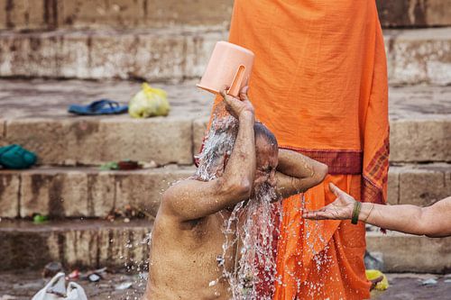 een man wast zichzelf in de rivier de Ganges tijdens hindoe puja, Varanasi, India