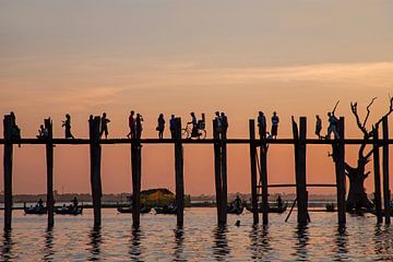 De U Bein brug bij zonsondergang bij zonsondergang met mensen die de Ayeyarwady River oversteken in Mandalay, Myanmar Azië van Eye on You