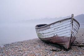 Bateau usé par les intempéries sur une plage de galets sur Art & Soul Creations