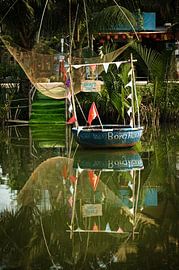 Tropical setting with a colourful traditional boat by Frank Photos