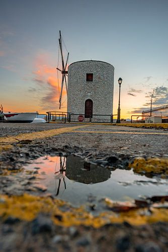 Griekse windmolen bij de haven in Corfu bij zonsopgang