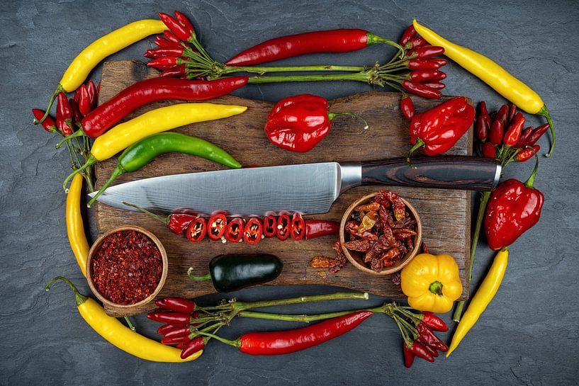 Chilis et poivrons colorés sur une planche en bois avec un couteau par Photo Art Thomas Klee