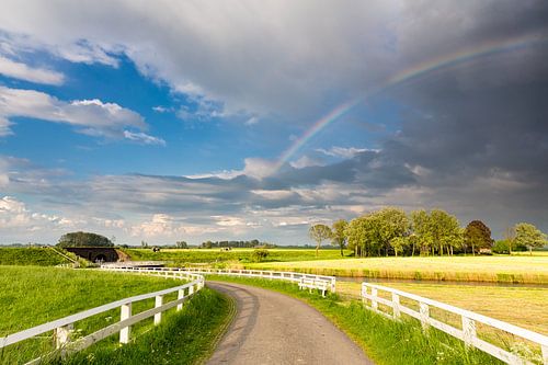 Een regenboog boven het landschap bij Aduarderzijl in Groningen van Bas Meelker