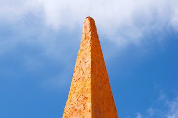 Orangefarbener Stein im blauen Himmel
