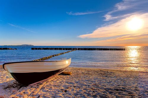 Zonsondergang, Sunset strand zee en bootje aan het strand, Rügen. van Twan van den Hombergh