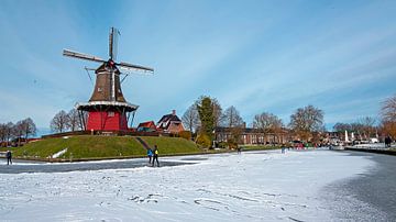 Schaatsen bij de molen in Dokkum in Nederland in de winter van Eye on You
