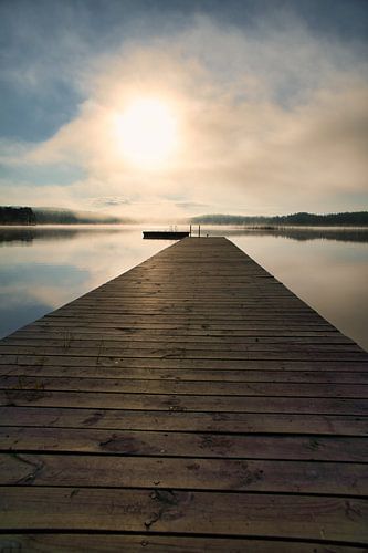 Loopbrug, naar de zonsopgang, reikend in een Zweeds meer