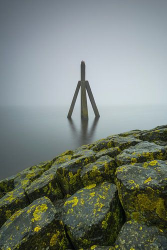 Een kijkje in de mist over de basalt keien naar de dukdalf Lauwersoog