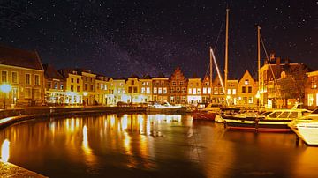 A clear starry sky over the beautifully lit harbour of Goes by Gert van Santen