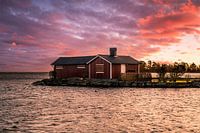 Zweeds huis op het water in de zonsondergang Sunnana hamn