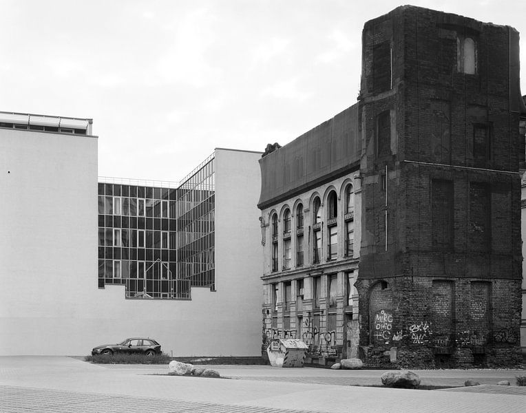 Contrastes dans le centre-ville de Leipzig - ruine du Karlshof à côté d'une façade de bureau lisse par Michael Moser