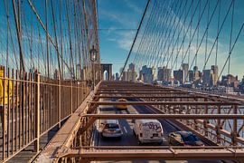Brooklyn Bridge in NYC daylight view with cars moving on the bridge ,skyline and clouds in sky in ba by Mohamed Abdelrazek