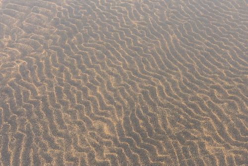 Vulkanisch zand golven in het water