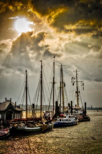 Schepen in de museumhaven Övelgönne Hamburg en wolken tegen het licht