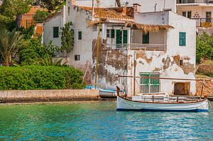 Idyllischer Blick auf ein altes Fischerboot, das an der Küste eines mediterranen Dorfes vertäut ist