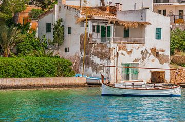 Idyllischer Blick auf ein altes Fischerboot, das an der Küste eines mediterranen Dorfes vertäut ist von Alex Winter