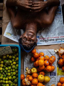 Slapende man op een fruitmarkt in Colombo, Sri Lanka van Teun Janssen