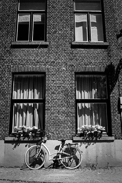 Bicycle on the wall of the house in Bruges by Patrik Hochnadel