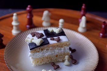 Gâteau d'échecs avec des pièces d'échecs en chocolat blanc et en chocolat au lait