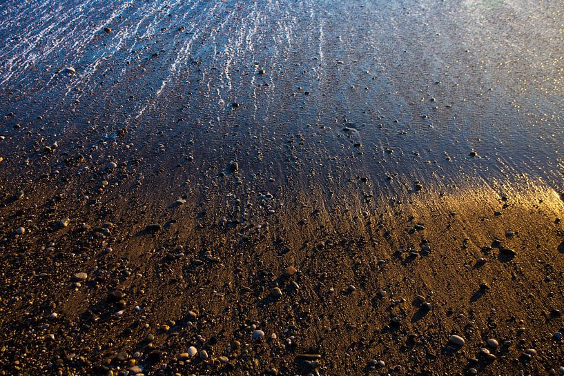 Golden sand and stones, wet from the departing wave, seashore by Michael Semenov