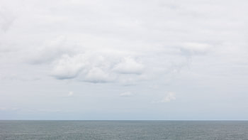 Verstild zeegezicht met wolkjes