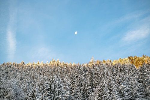 first sun with snow-covered mountains and moon