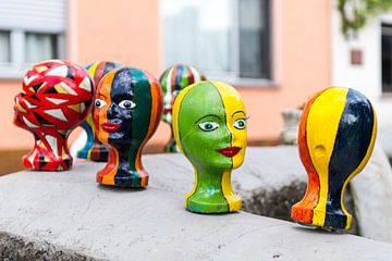 Têtes multicolores sculptées sur Wim Stolwerk