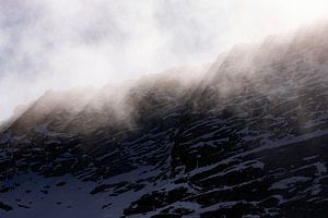 Sonnenlicht, das durch eine Felswand in den Alpen ragt.