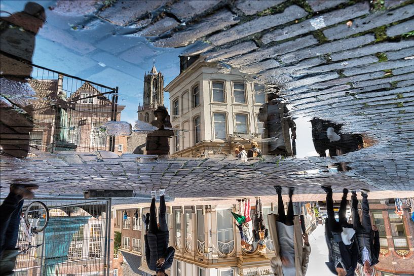 Tussen de regenbuien door weerspiegelt de Utrechtse Domtoren in een plas. von Margreet van Beusichem