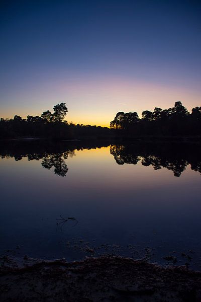 Sunset with beautiful reflections in a windless water. by Margreet Frowijn