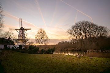 Winters landschap met molen en zonsondergang in Nederland van Elles van der Veen