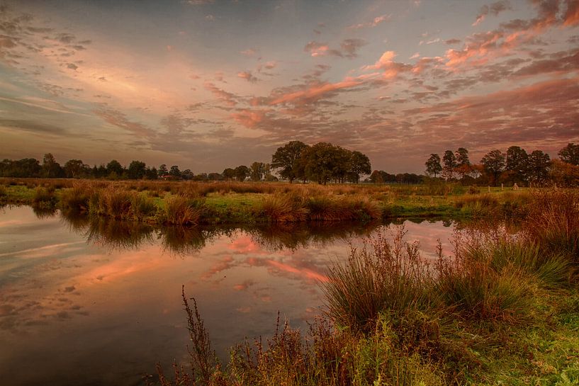 Bunte Wolken, die sich im Wasser spiegeln. von Tom Kruissink