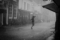 Jonge vrouw dans in de regen in zwart-wit