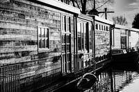 Wooden houseboat in low sun mirroring in water