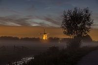 Verlichte molen Kinderdijk in mistbank